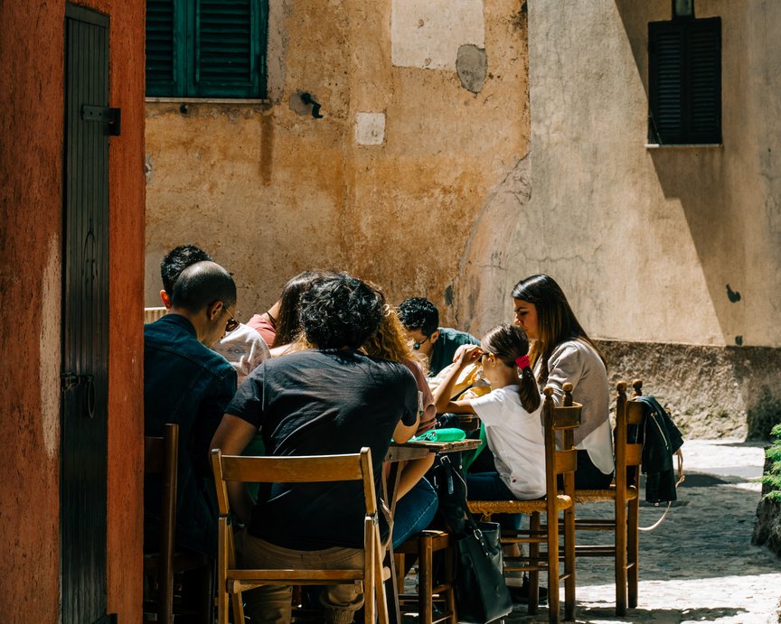 Family eating together and spending time together in the small streets of Spain