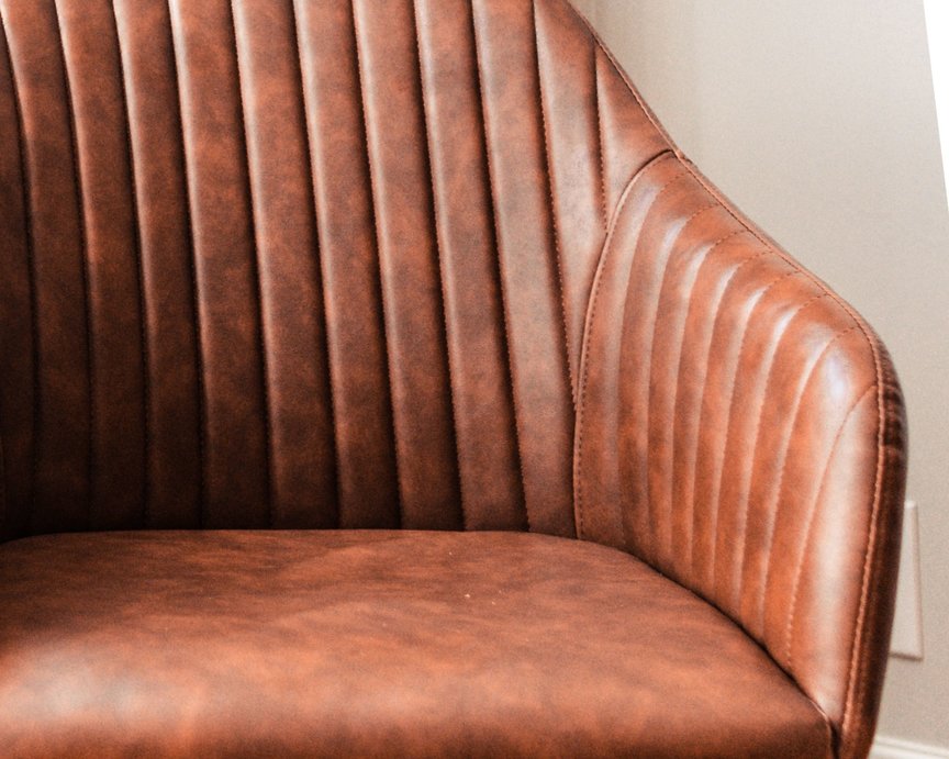 Brown bonded leather arm chair with straight-lined design.