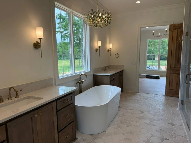 Bright primary bathroom with freestanding tub and custom cabinetry