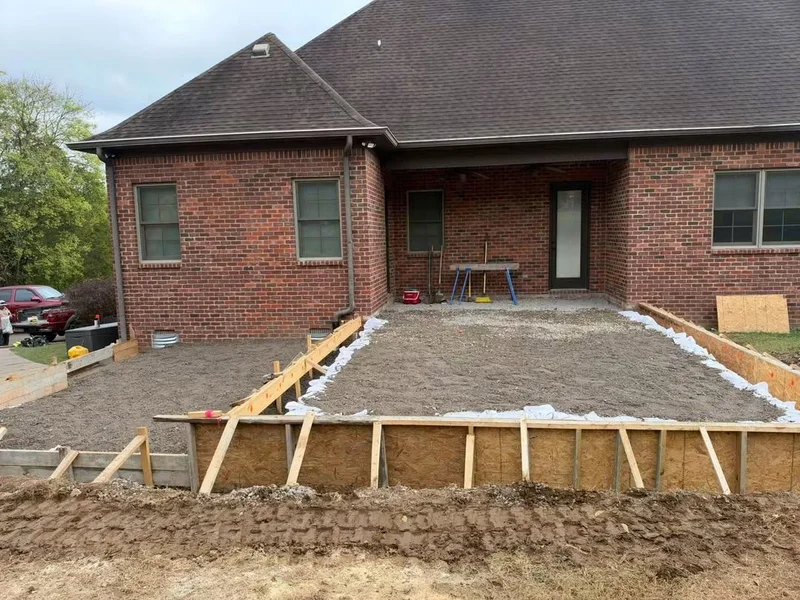 Patio foundation preparation beside a brick home