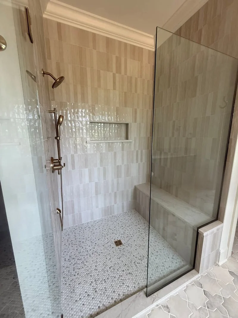 Walk-in shower with warm tile, built-in bench and glass enclosure