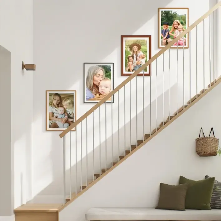 Family photo frames displayed along a bright staircase wall