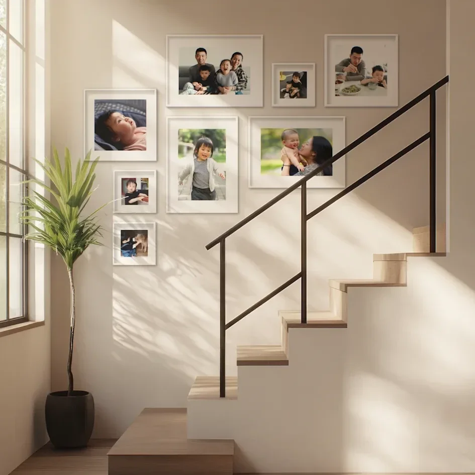 Sunlit staircase with gallery wall of family photos and plant