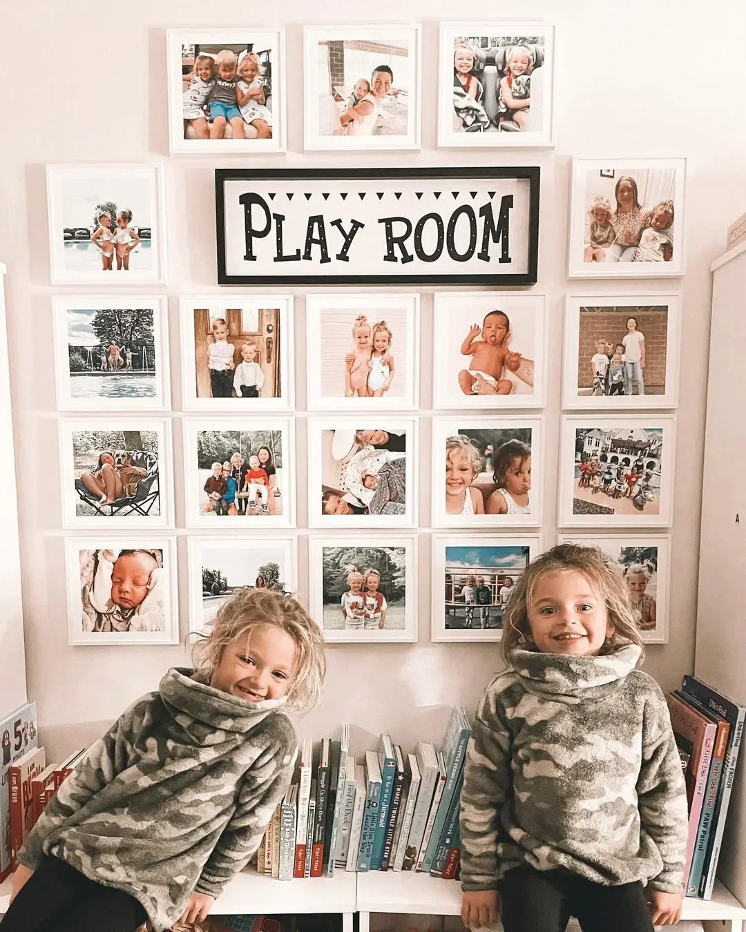 Kids standing behind Mixtiles frames in their playroom