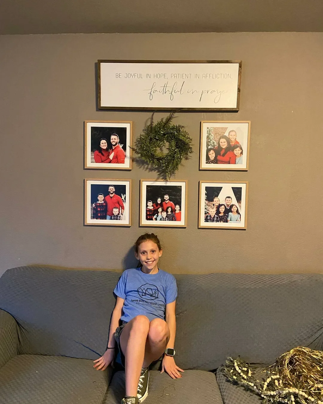 Girl sitting on sofa with Mixtiles frames behind her