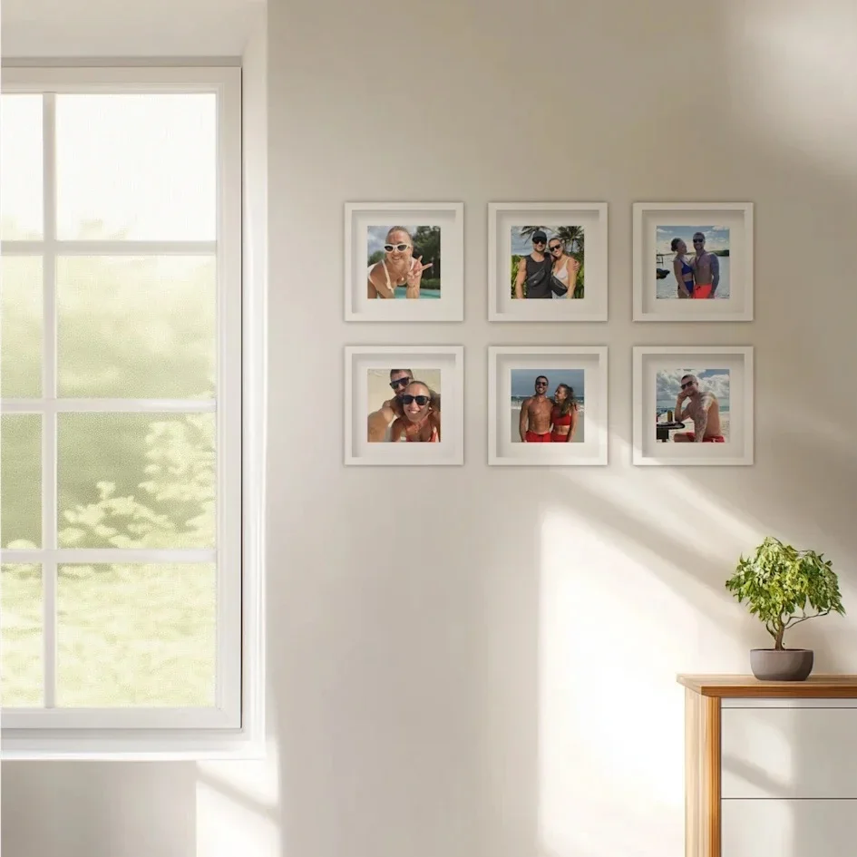 Sunlit wall with six framed beach couple photos in white frames