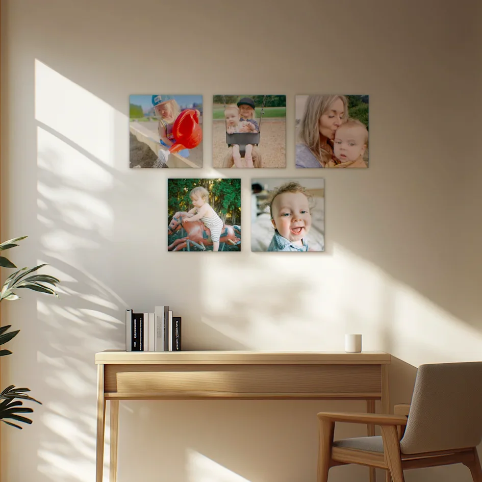 Sunlit console table beneath five baby photo canvases