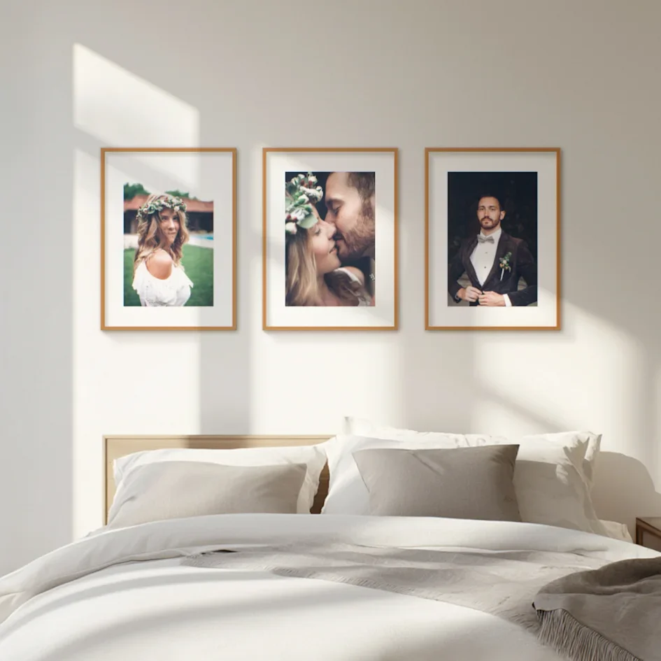 Minimal bedroom wall with trio of wedding portraits above headboard