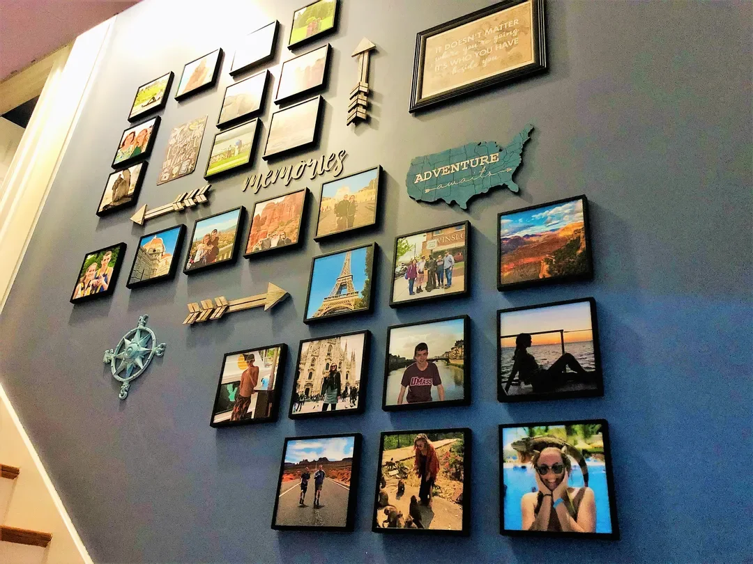 A staircase wall arranged with travel photos displayed along with an indicator of travels.