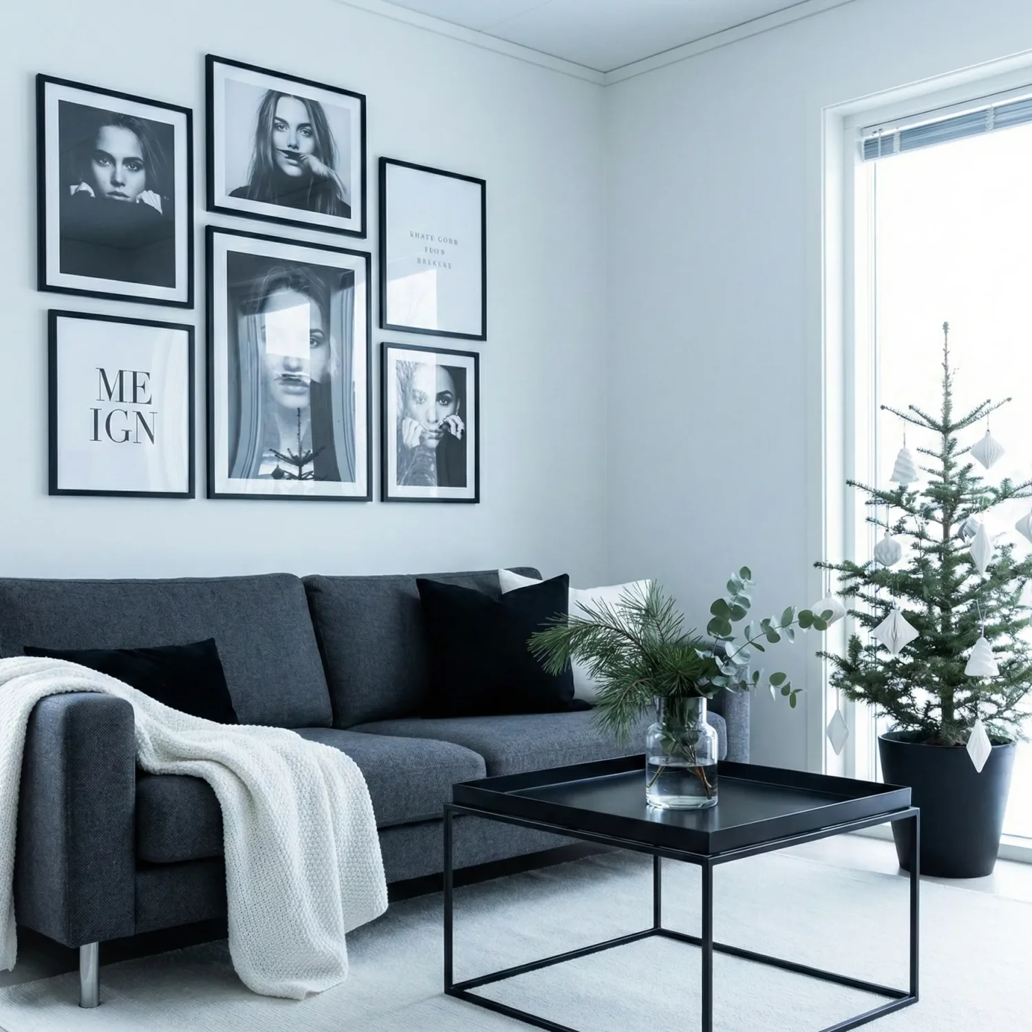 Minimalist lounge with black-and-white art and small christmas tree.