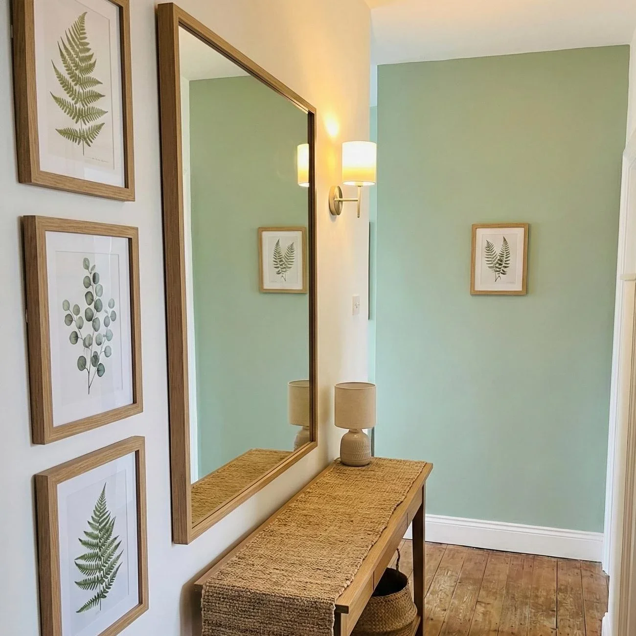 Bright hallway with botanical prints, wood console, and mirror