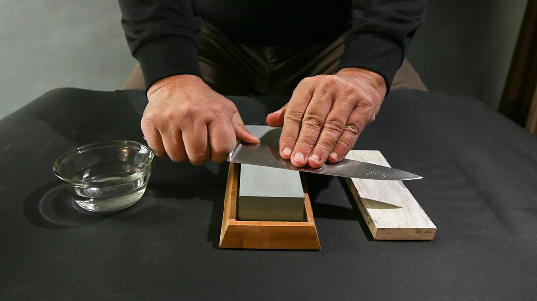 sharpening a knife on a whetstone