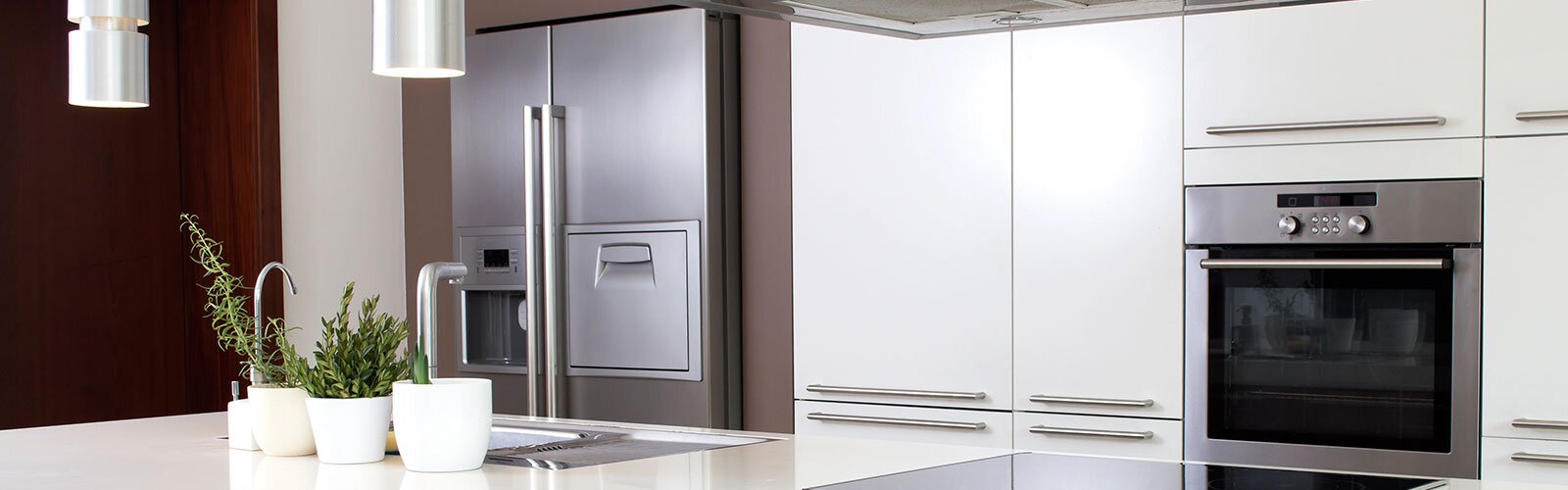 A clean, bare kitchen with stainless steel appliances. 
