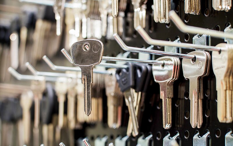 Blank keys hang from hooks on a wall display. 