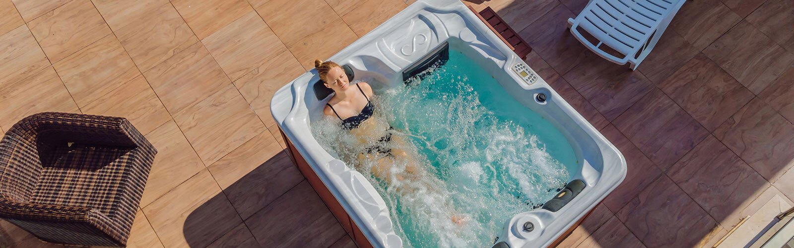 A woman blissfully relaxing in her hot tub outside.