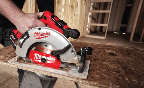 A circular saw is cutting a piece of lumber.
