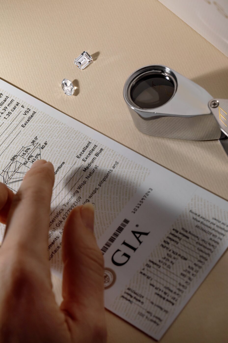 Loose diamonds with GIA certificate and magnifying glass tool