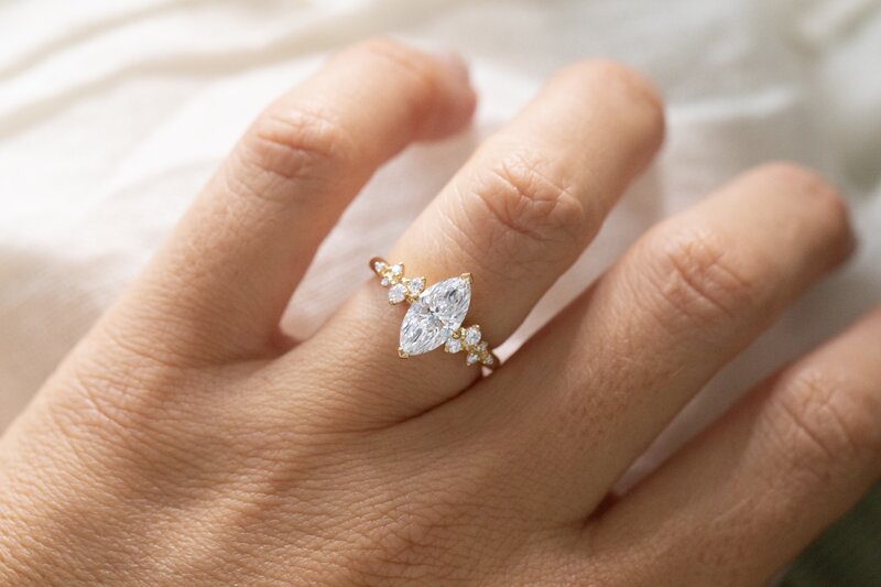 cluster marquise engagement ring in yellow gold on a hand morning star