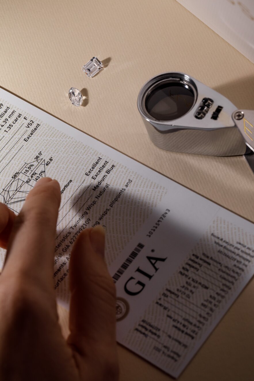 jeweller inspecting loose diamonds and their GIA certificate