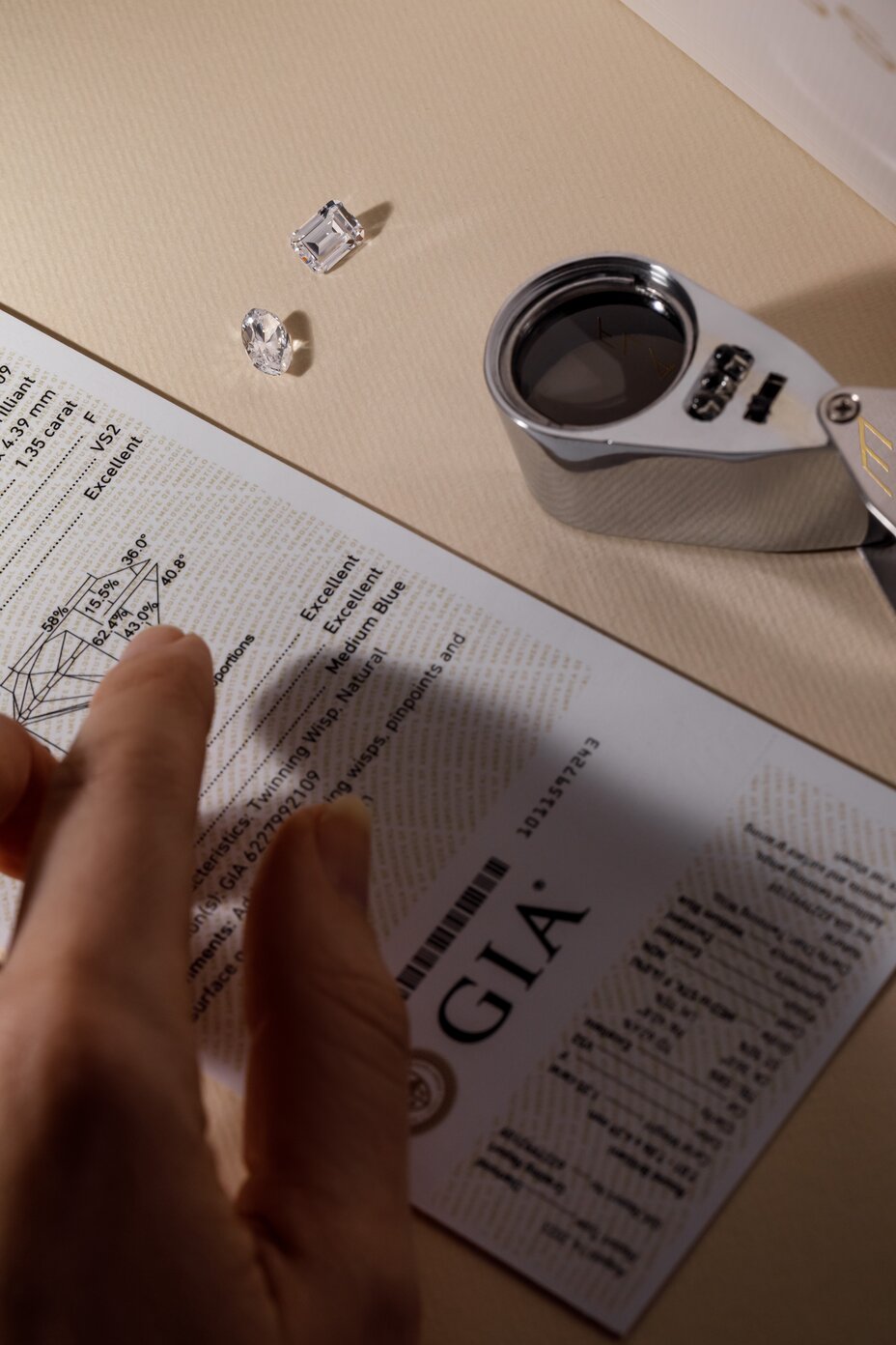 jeweller inspecting loose diamonds and their GIA certificate