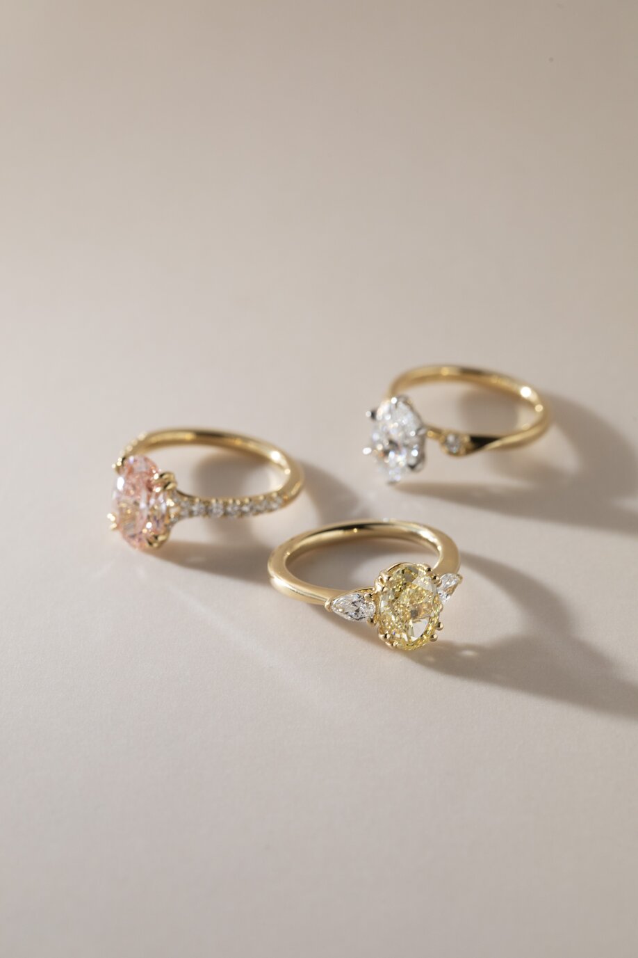 mixed styles of oval diamond engagement rings in yellow gold featuring white, pink and yellow ovals