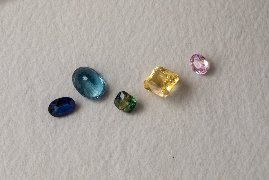 Loose sapphire gemstones in various colours including blue, pink, yellow and green in different cuts and shapes
