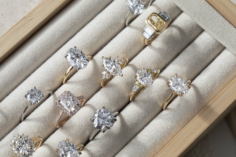 Diamond engagement rings in a ring display box featuring multiple styles, metals and diamond shapes
