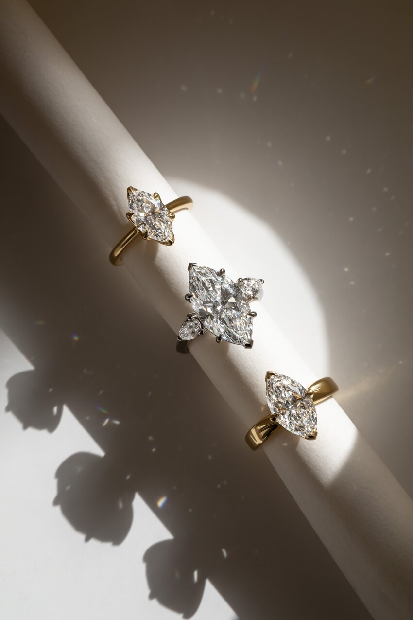 Marquise cut diamond rings in yellow and white gold featuring solitaire and three-stone designs.