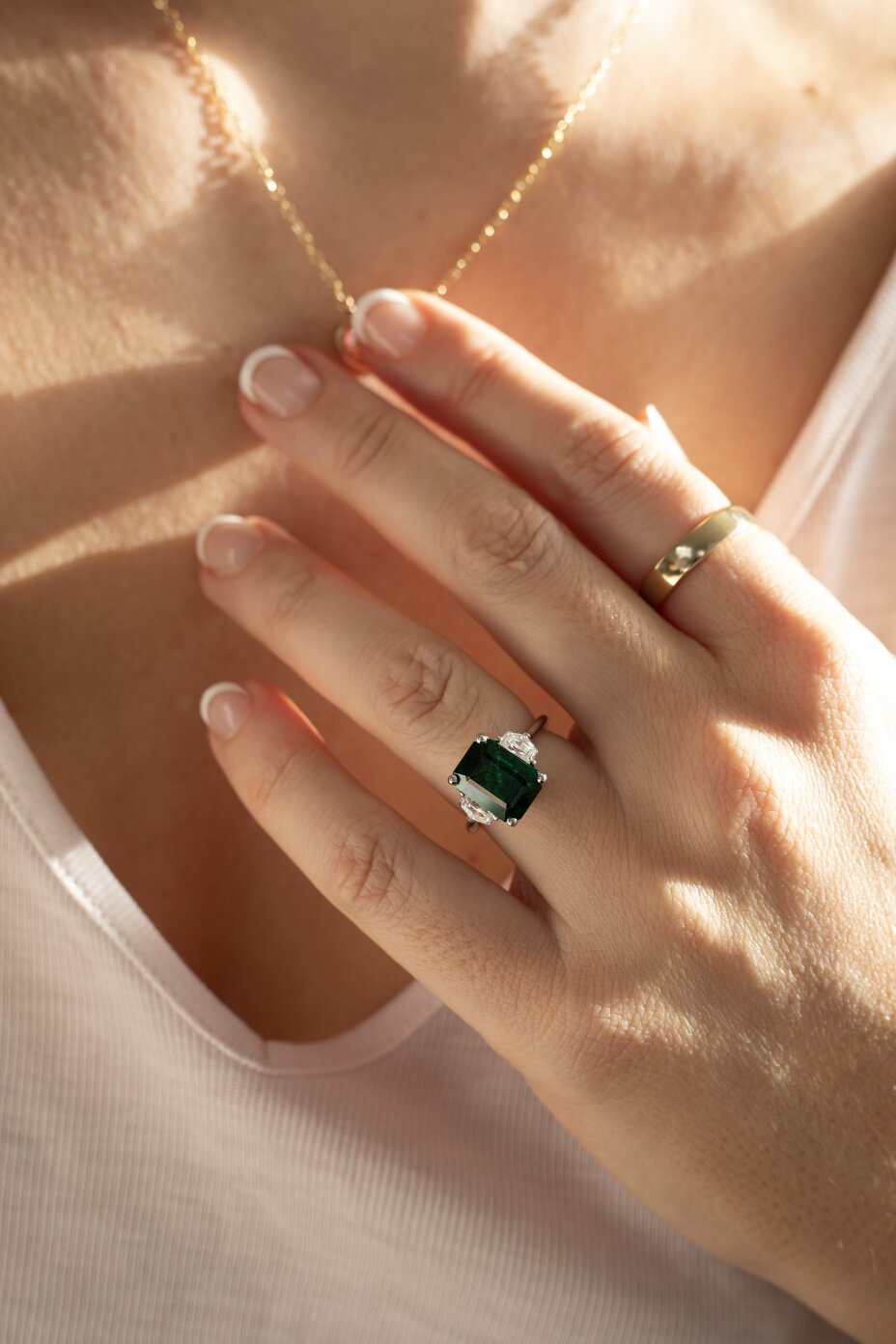 green Emerald gemstone trilogy ring in platinum with step cut, trapezoid sides, trey
