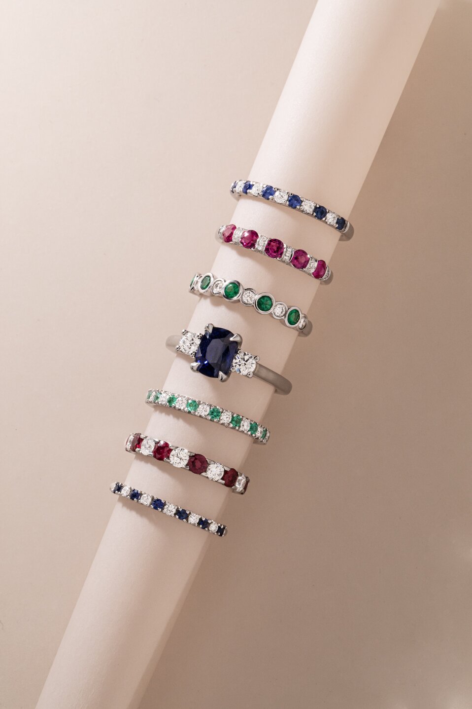 A variety of diamond and gemstone eternity rings including sapphires, rubies, and green emeralds.