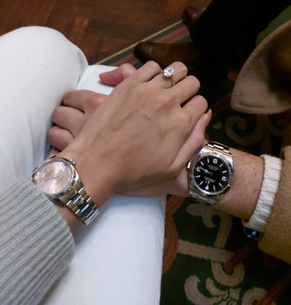 Hand wearing Oval Engagement Ring while couple shares a special moment together.