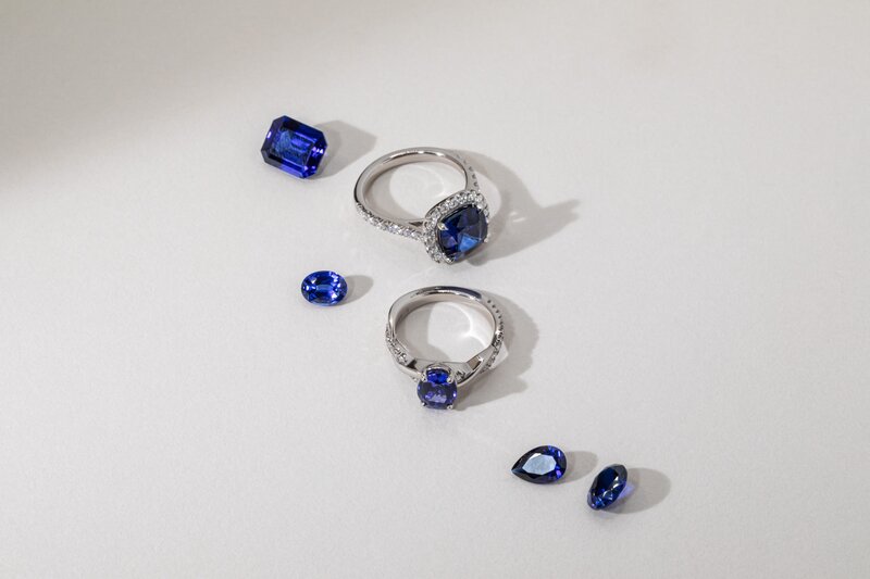 Blue sapphire engagement rings in platinum with loose sapphire gemstones in various cuts and shapes