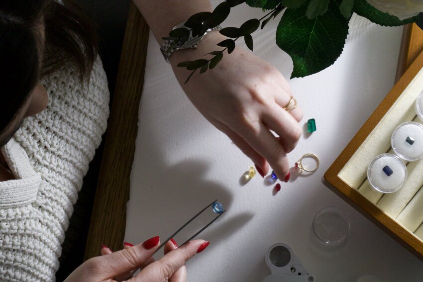 Experts evaluating coloured gemstones using specialist equipment for accurate authenticity verification.