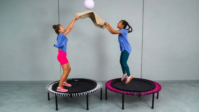 Kids playing on the bellicon mini rebounder with a ball.