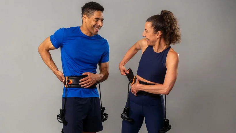 Een man en een vrouw dragen de Shadowboxer-riem en lachen.