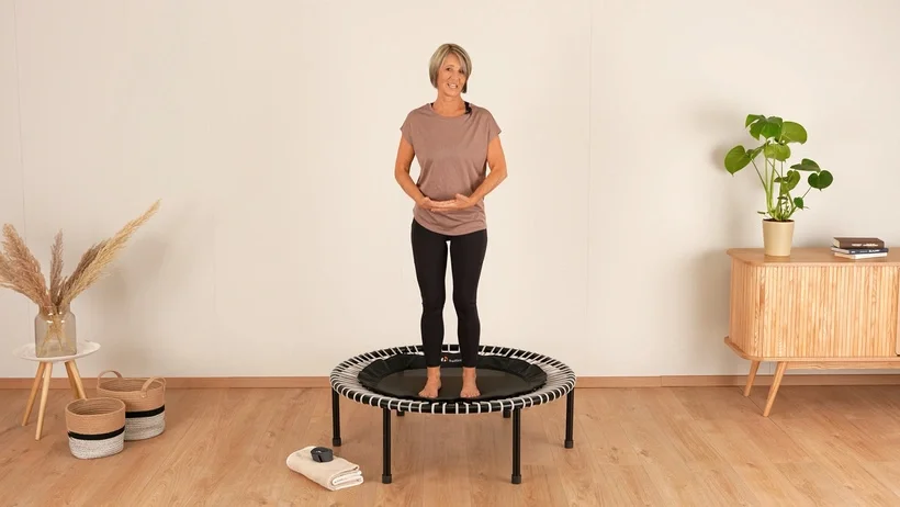Frau steht aufrecht auf dem bellicon Minitrampolin.