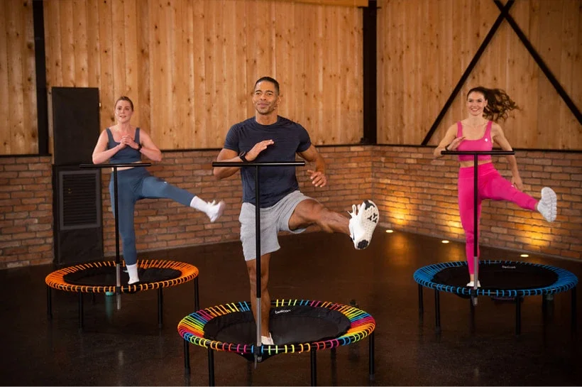 Trois personnes s'entraînent ensemble sur des mini-trampolines.