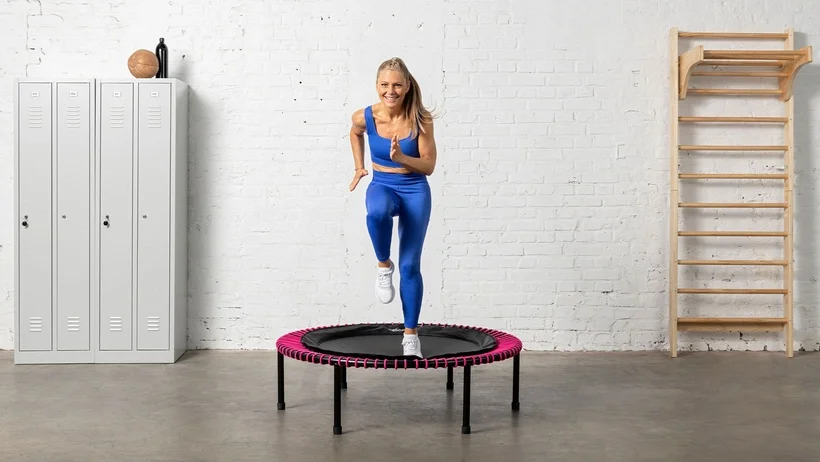 Young woman is doing an intense cadio workout on the bellicon rebounder.