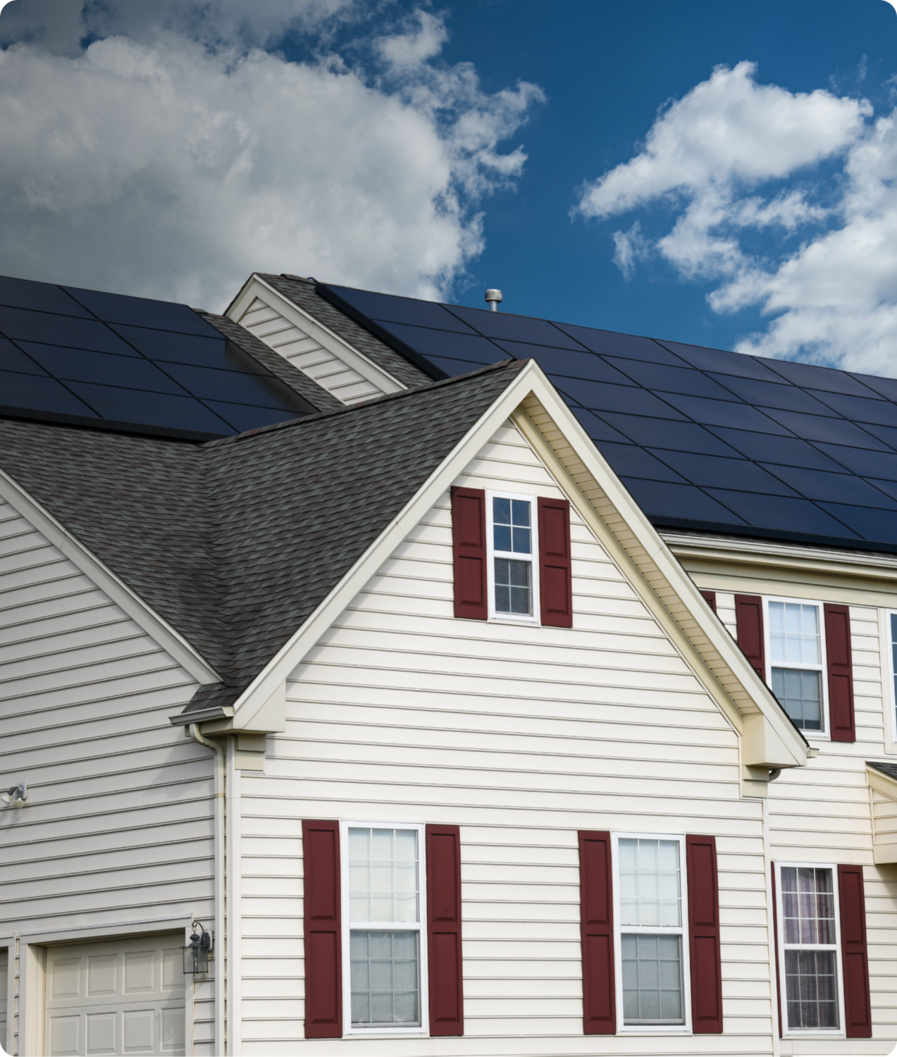 Residential solar energy project on rooftop of a white house with blue sky