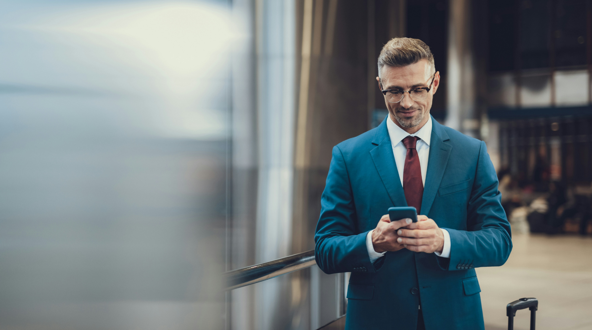 Man in blauw pak die een telefoon vasthoudt