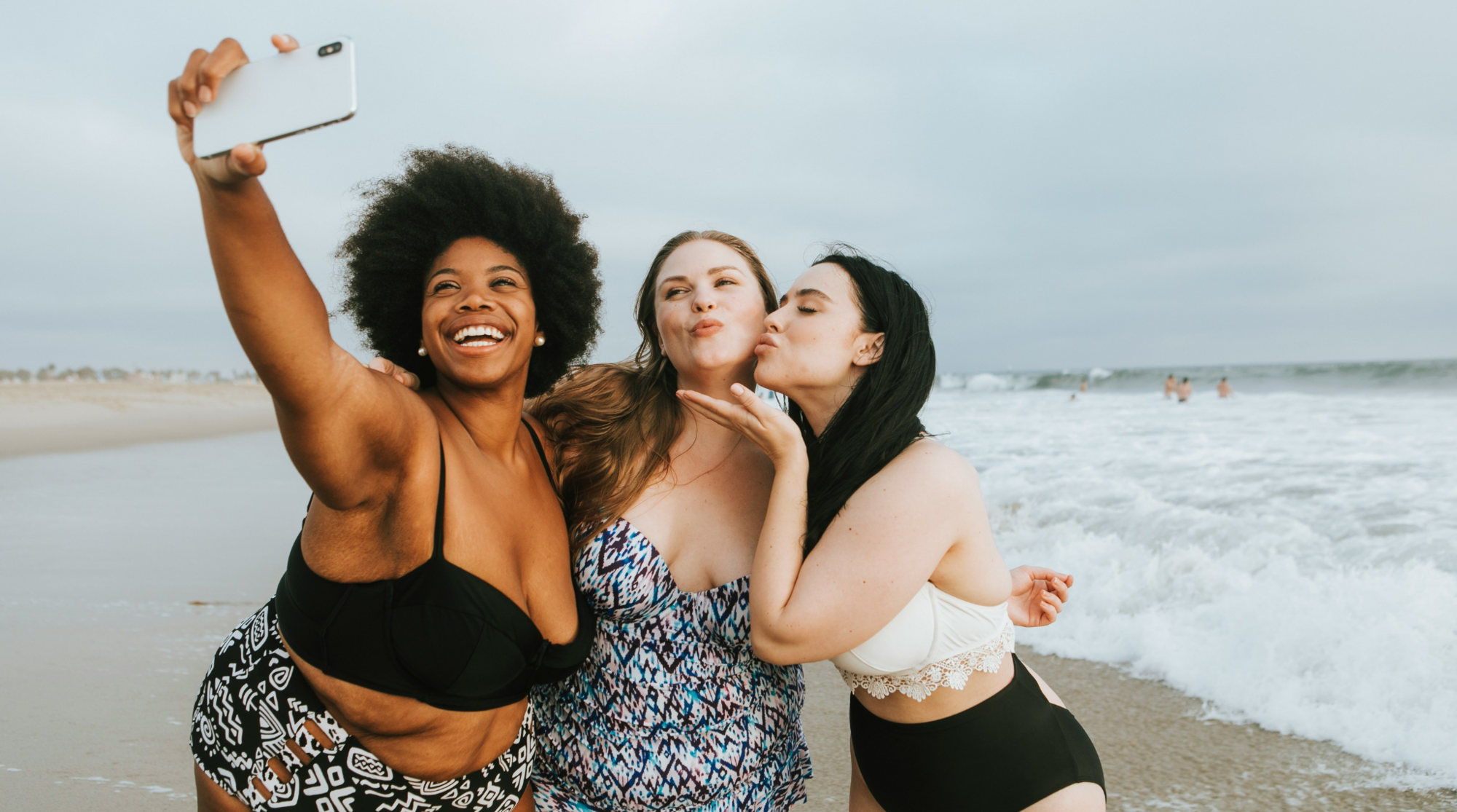 Drie vrouwen die een selfie nemen op het strand