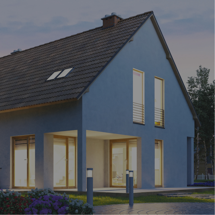 Modernes Einfamilienhaus bei Dämmerung mit eingeschalteter Innenbeleuchtung und Garten im Vordergrund.
