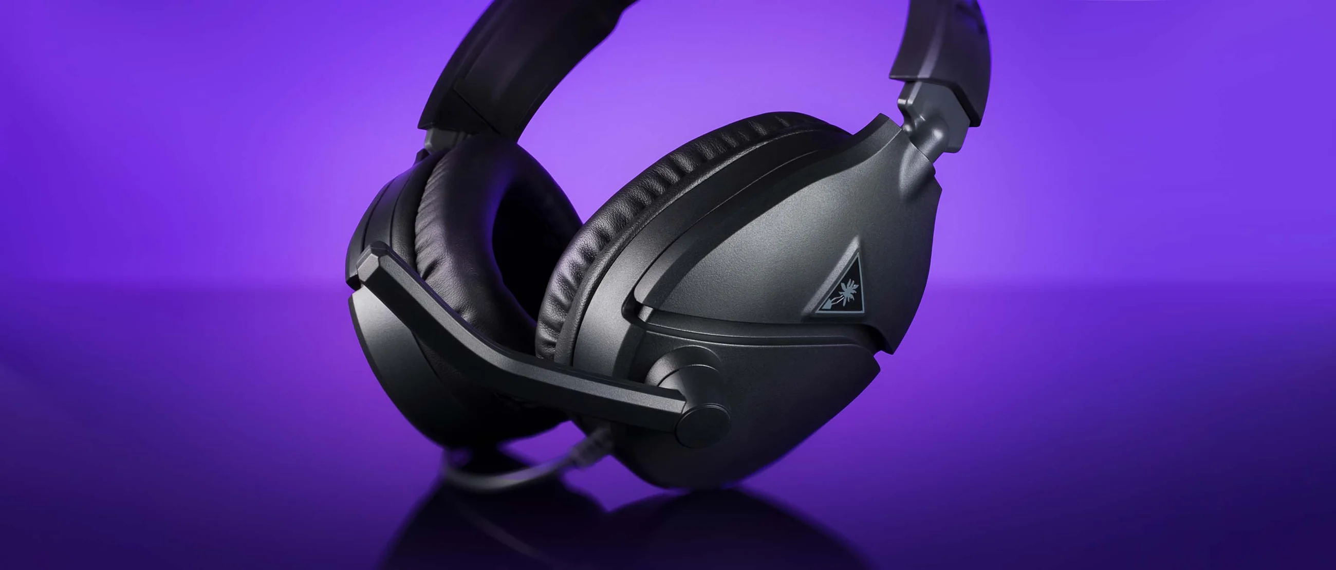 Sleek black Recon 70 gaming headset with plush ear cushions on purple background
