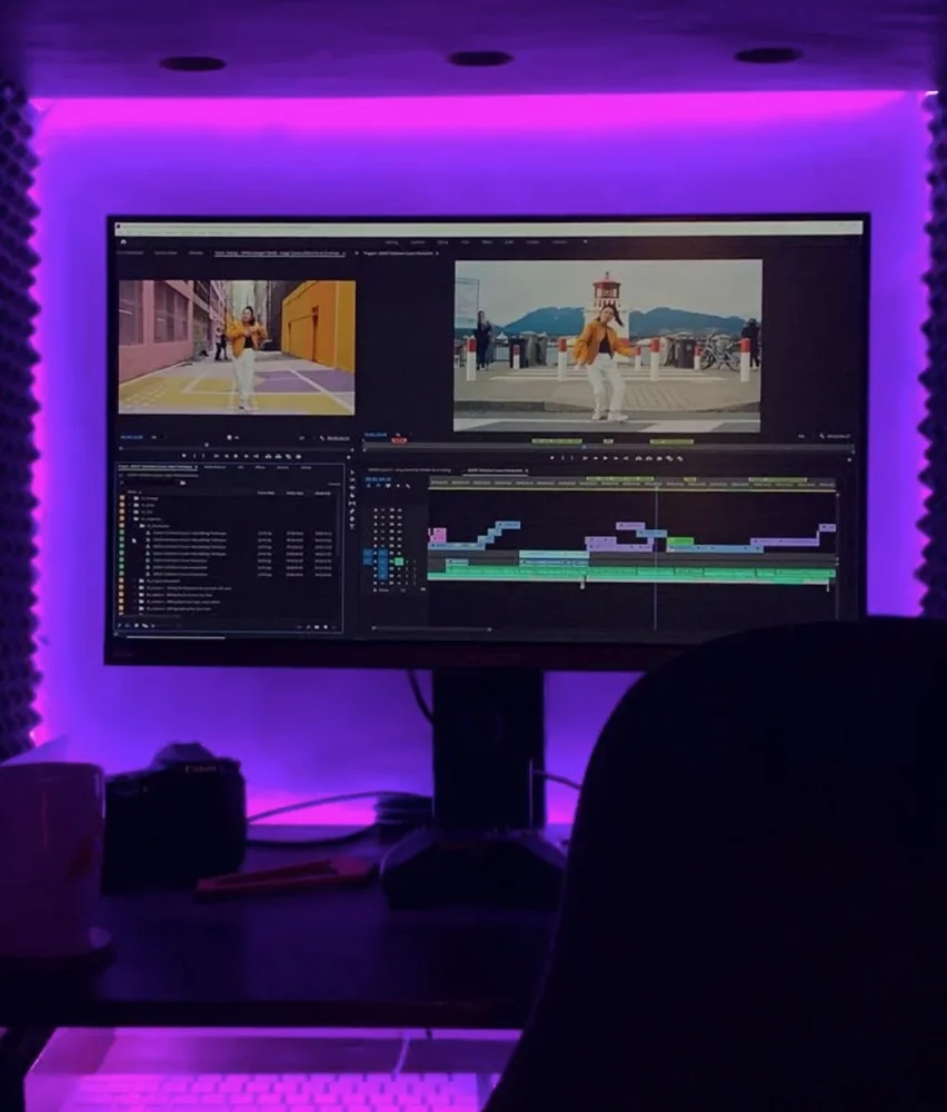 Photo of a computer monitor showcasing editing software, in a purple room