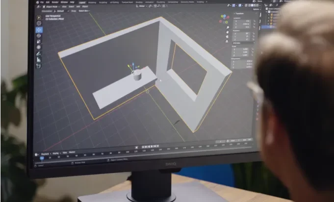 A man intently examines a computer screen displaying a detailed 3D model.