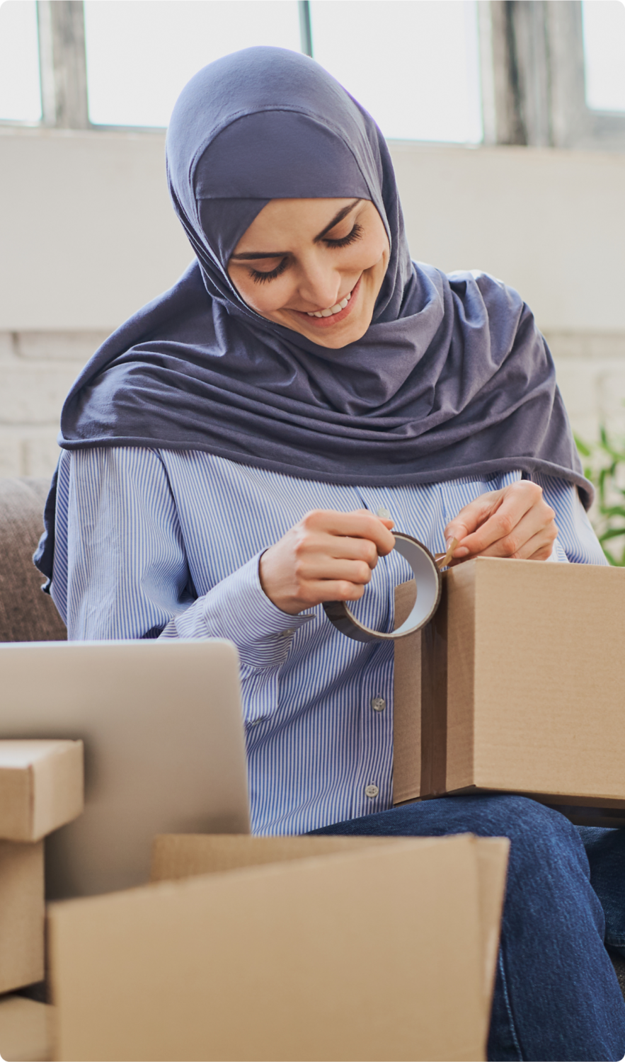 A woman wearing a hijab tapping a box closed.