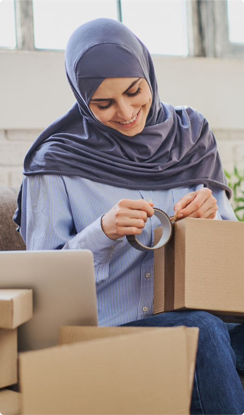 A woman wearing a hijab tapping a box closed.