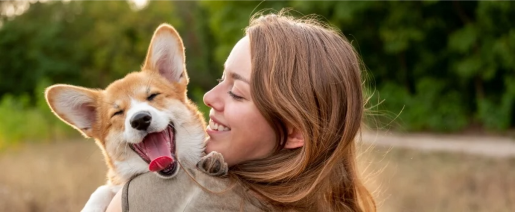 dog yawning while being held by woman