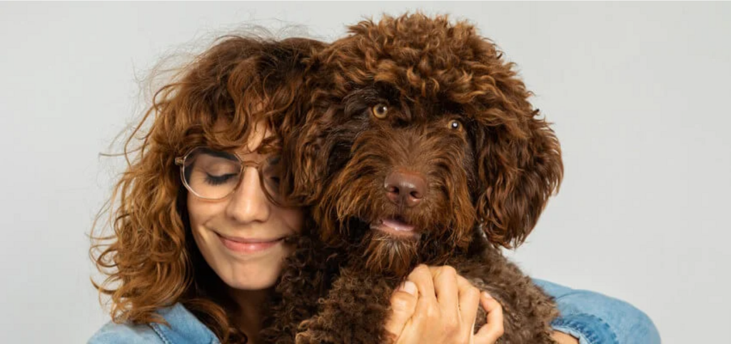 woman cuddling labradoodle