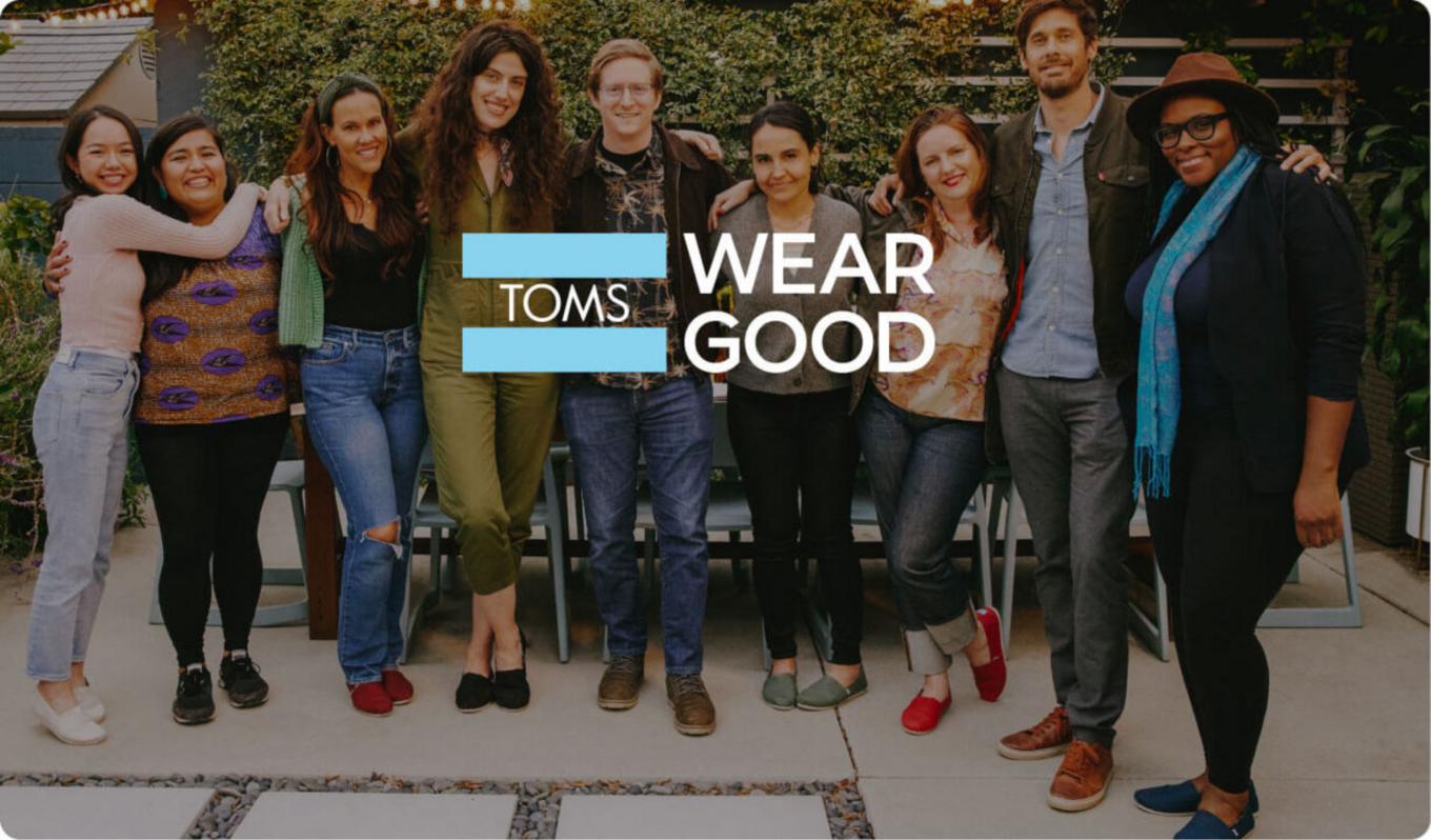 TOMS Wear Good logo overlaying an image of a group of people.